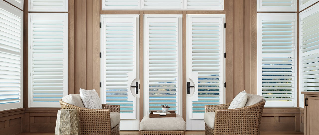 Beautiful stylish shutters with brown woven seating and shite cushions. 